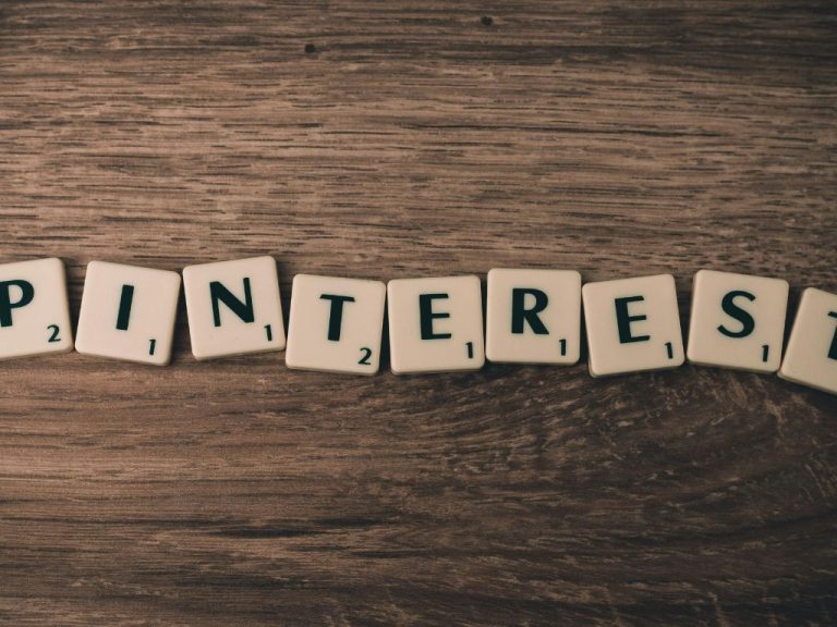 Scrabble tiles spelling 'Pinterest' on a wooden background.