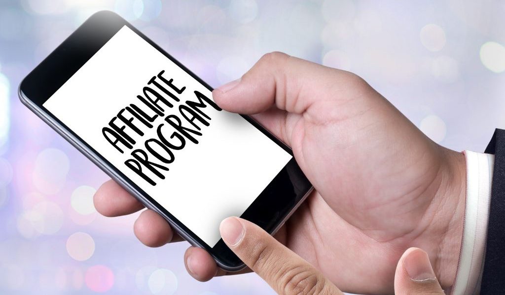 Person tapping on a smartphone screen that displays "Affiliate Program," symbolizing online affiliate marketing or niche program selection.