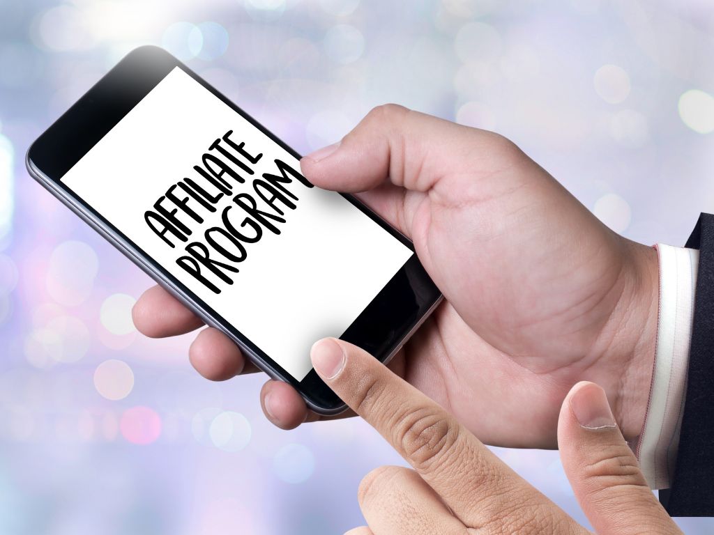 Person tapping on a smartphone screen that displays "Affiliate Program," symbolizing online affiliate marketing or niche program selection.